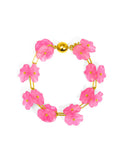 A bracelet with a pink  lotus flower design and a gold-colored clasp