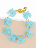 A bracelet with a blue lotus flower design and a gold-colored clasp.