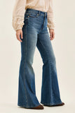 Flared jeans worn by a person on a plain background