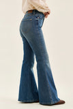 Blue bell-bottom jeans worn by a person on a beige background