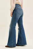 Flared blue jeans worn by a person on a beige background