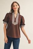 Woman wearing a brown blouse with a striped collar against a beige background