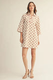 Woman wearing a polka dot dress on a plain background