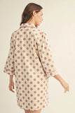 Woman wearing a polka dot nightshirt on a beige background
