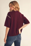 rear view burgandy sweater with stitching on sleeves

