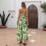 Woman wearing a strapless green and white floral jumpsuit in an outdoor setting.