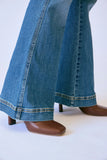 Close-up of blue jeans and brown shoes on a white background