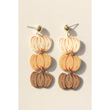 Pair of pumpkin-shaped earrings on a beige background