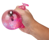 Hand holding a pink and clear stress ball with colorful confetti on a white background
