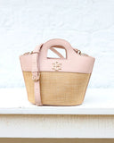 Pink and straw handbag on a white surface with a light blue textured background