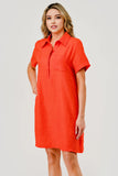 Woman wearing an orange dress against a plain background