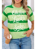 Person wearing a green and white striped sweater with text, standing indoors.