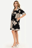 Woman wearing a black floral dress on a white background
