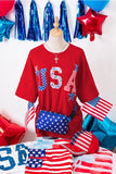 Red shirt with 'USA' design on a mannequin, surrounded by American flags and balloons.