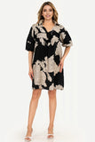 Woman wearing a black floral dress on a white background