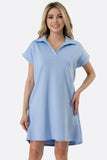 Woman wearing a light blue dress with a collar on a white background