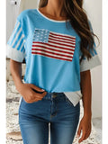 Person wearing a blue t-shirt with an American flag design and blue jeans.