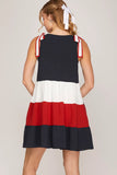 Woman wearing a dress with a color block design on a plain background