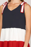 Navy, white, and red dress with bow straps on a person.