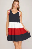 Woman wearing a dress with a color-block design on a plain background