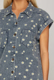 Denim dress with daisy pattern worn by a person on a neutral background