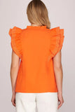 Orange top with ruffled shoulders worn by a person on a plain background