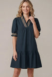 Woman wearing a dark blue dress with a beige background