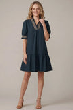 Woman wearing a dark blue dress with a beige background