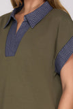 Green dress with blue striped collar and cuffs on a plain background