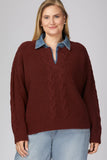 A woman wearing a burgundy cable-knit sweater with a blue denim collar, paired with light blue jeans, against a solid gray studio background.