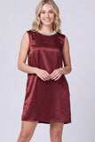A woman modeling a sleeveless, knee-length satin dress in a deep burgundy color, featuring a decorative pearl collar, set against a plain light gray studio background.