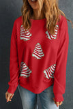 Person wearing a red sweater with candy cane tree patterns against a dark background