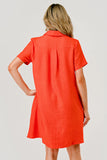 Person wearing an orange dress against a plain background