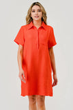 Woman wearing a bright orange dress against a plain background