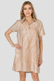Woman wearing a beige patterned dress on a plain background