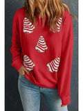 Red sweatshirt with christmas cake  tree designs worn by a person against a dark background