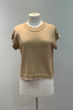 Beige sweater on a mannequin against a plain background