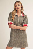 Woman wearing a patterned dress with red and white trim on a plain background