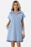 Woman wearing a light blue dress with a collar on a white background