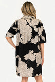 Woman wearing a black floral dress with beige flowers on a white background