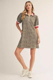 Woman wearing a patterned dress with short sleeves and white sneakers on a beige background