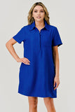 A woman modeling a short-sleeve collared shift dress in a vibrant royal blue color, set against a solid light gray studio background.