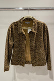 A leopard print jacket hanging on a wooden hanger against a plain light gray wall. The jacket features a tan and brown animal print pattern with a solid tan lining visible at the open front.