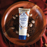 Naked Bee Spiced Chai & Honey lotion tube on a wooden surface with spices