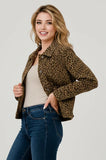 A woman modeling a cropped leopard-print jacket over a beige top and blue jeans, photographed against a plain light gray studio background.