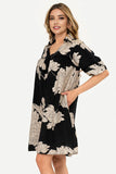 Woman wearing a black floral dress on a white background