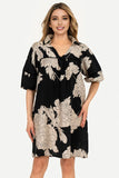 Woman wearing a black floral dress on a white background