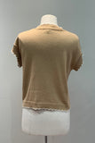 Beige short-sleeve sweater on a mannequin against a gray background