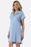Woman wearing a light blue dress with a collar on a white background