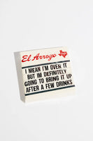 Small sign with text and 'El Arroyo' branding on a white background